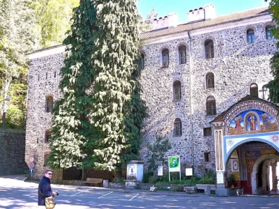 Mur Monastyru Rylskiego z freskiem nad bramą wejściową, w dole fotograf z aparatem