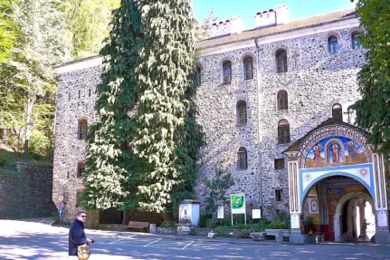 Mur Monastyru Rylskiego z freskiem nad bramą wejściową, w dole fotograf z aparatem
