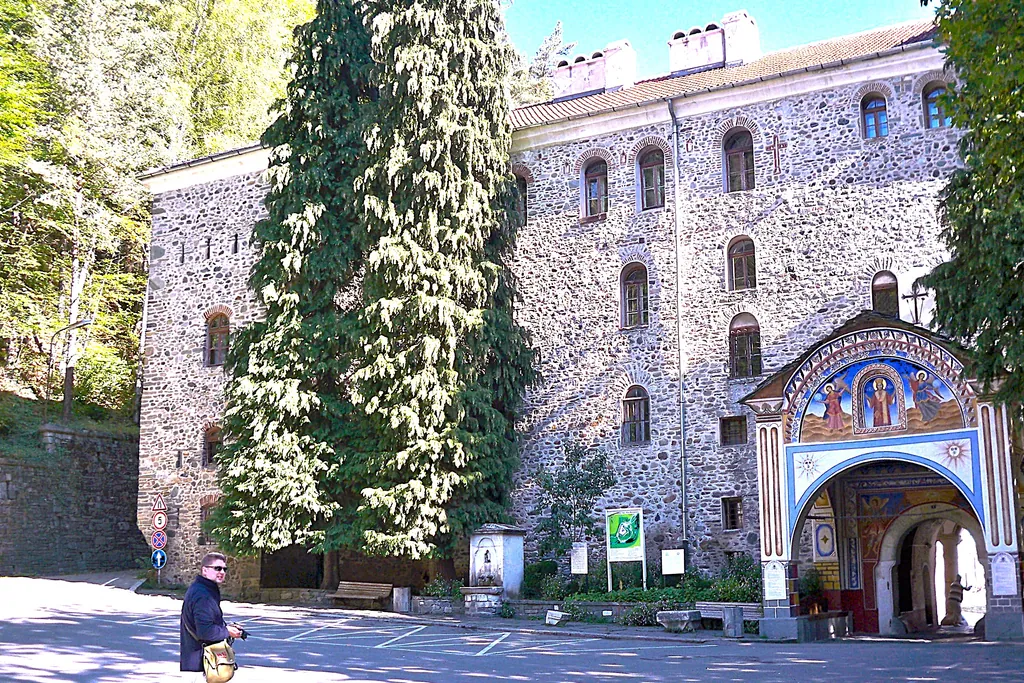 Mur Monastyru Rylskiego z freskiem nad bramą wejściową, w dole fotograf z aparatem